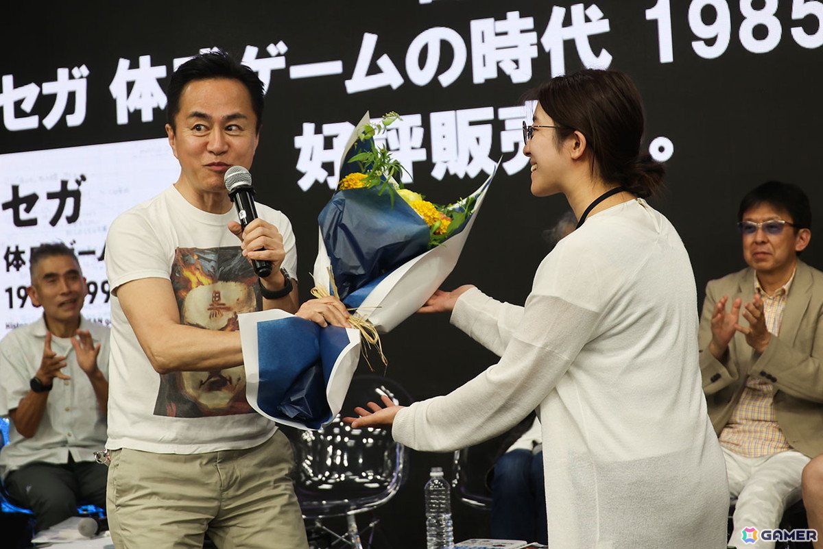 100回記念の花束を渡される黒川氏。