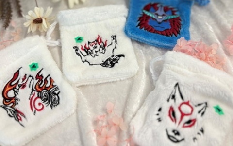 「大神」シリーズよりアマテラスとオキクルミの刺繍入りふわふわ巾着が登場！カプコンストアでは幸玉の飴が入ったもっふもっふな巾着バージョンも