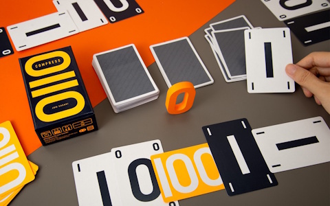 0と1の並びを記録するカードゲーム「コンプレス」がゲームマーケット2026春で発売！限られた手札で“メモ”を構築するシンプルながらも奥深いゲーム性に注目