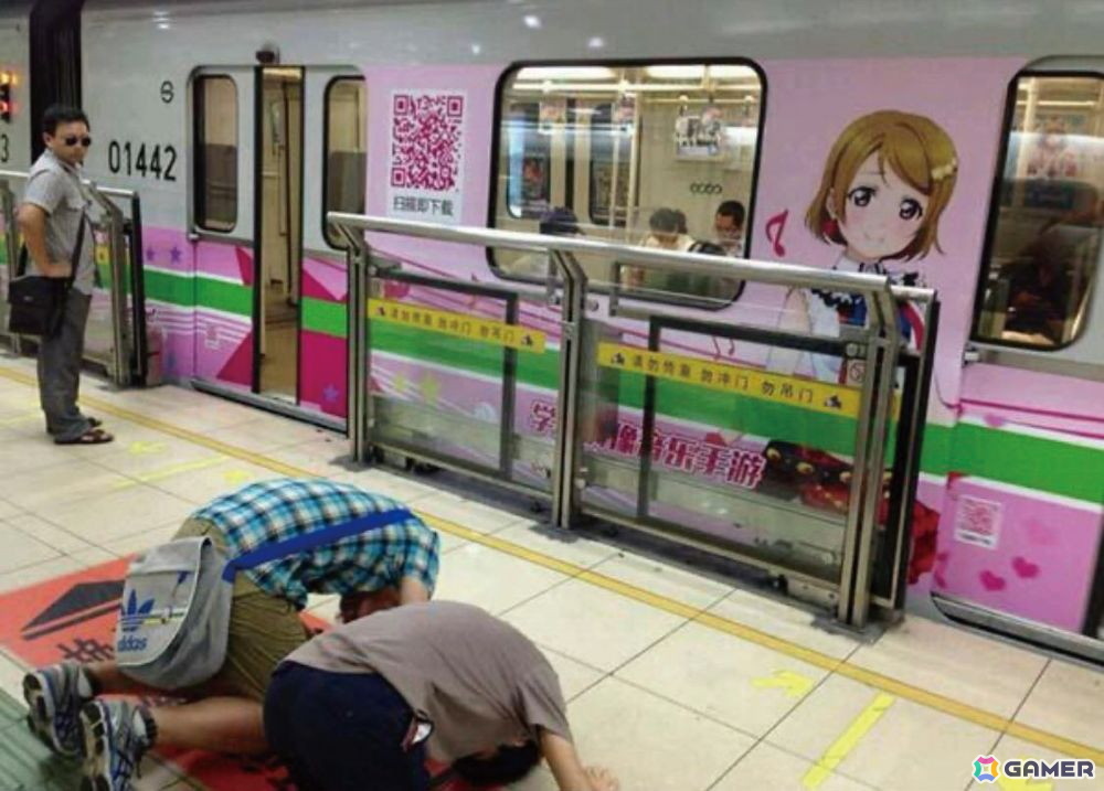「ラブライブ!」のファンが地下鉄でラッピング車両を崇拝している場面。